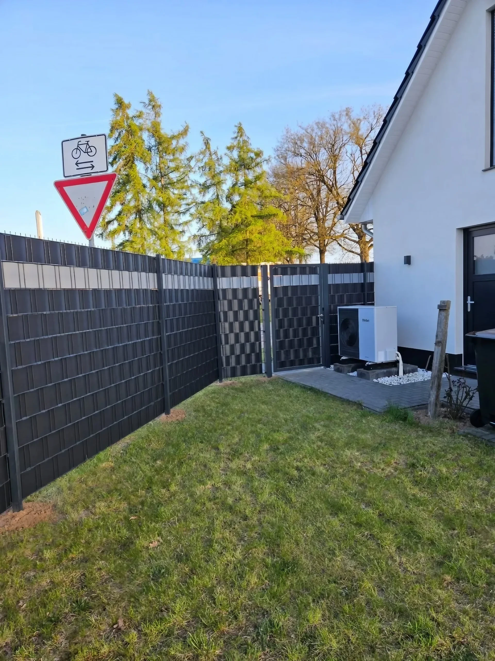 Doppelstabmattenzaun in Anthrazit mit Sichtschutzstreifen am Garten mit Wärmepumpe