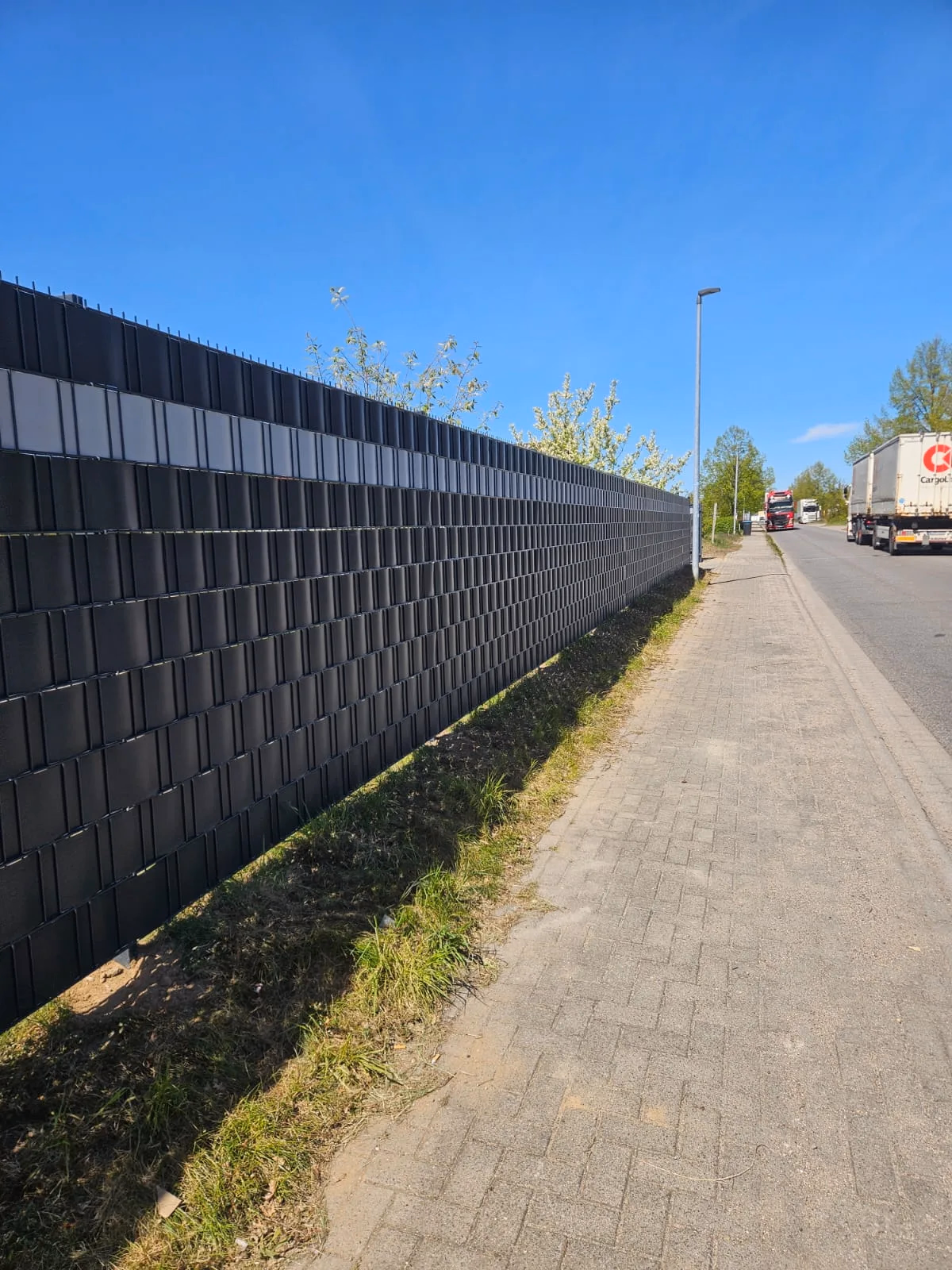 Doppelstabmattenzaun in Anthrazit mit Sichtschutzstreifen — langer Zaunverlauf im Gewerbegebiet