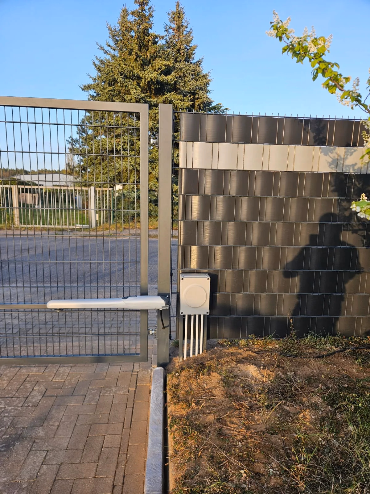 Torantrieb am Flügeltor — verzinkter Linearantrieb an einer Doppelstab-Toranlage mit Sichtschutz